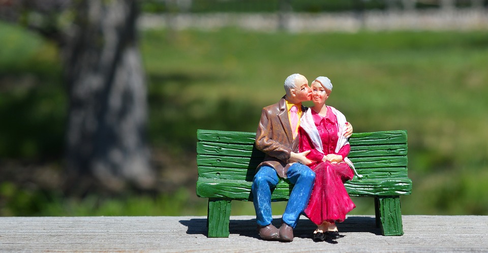 ベンチでキスする老夫婦の人形